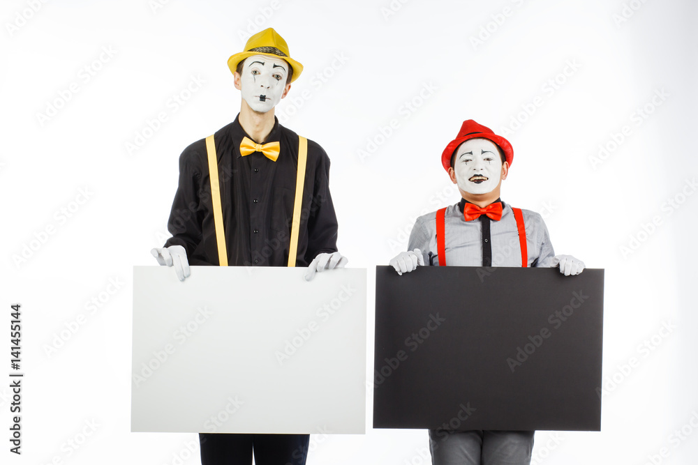 Two funny mimes holding a white blank on a white background. Two funny mimes holding a white blank on a white background.