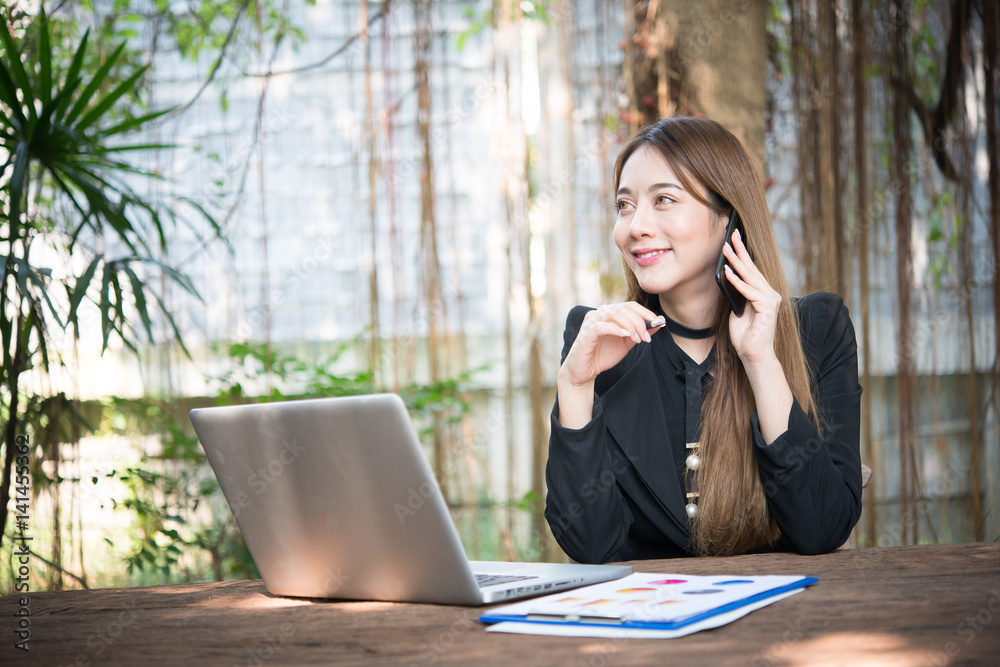 Young business woman talking on the phone while sitting at her working place. Young business woman talking on the phone while sitting at her working place.