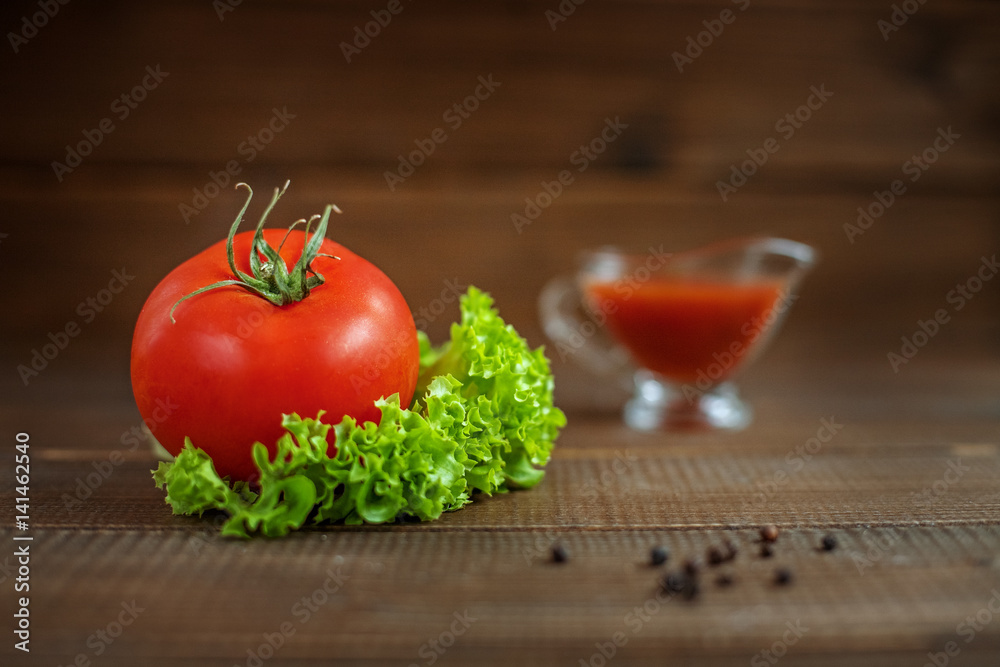 Sauce, lettuce and tomatoes on a wooden background. The concept of healthy eating and vegetarianism. Sauce, lettuce and tomatoes on a wooden background. The concept of healthy eating and vegetarianism.