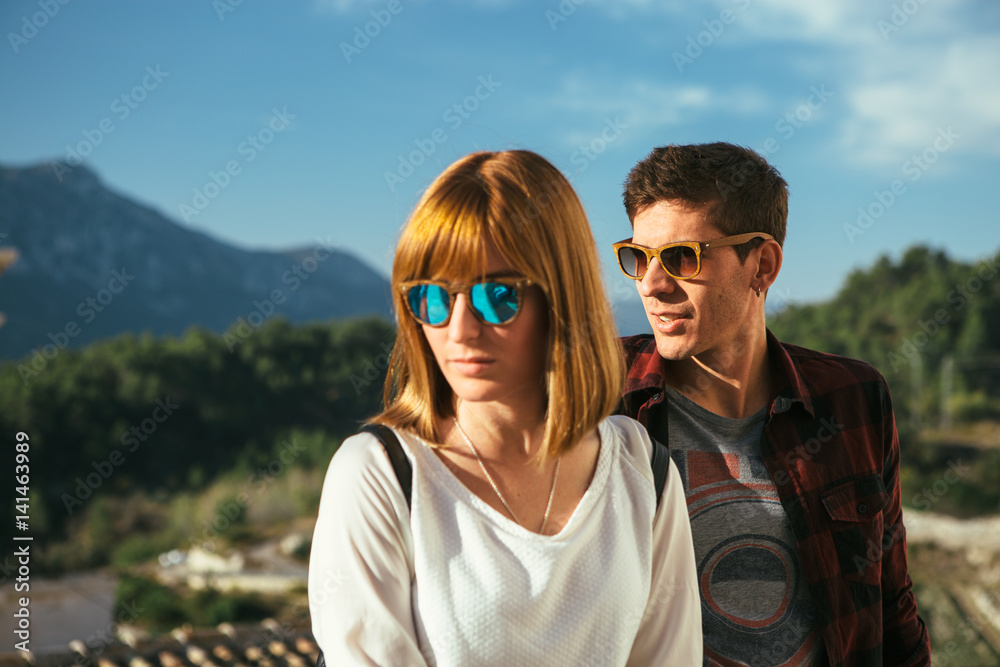 Young man and woman posing in sunglasses