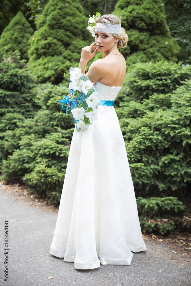 Blonde woman in wedding dress holding bouquet