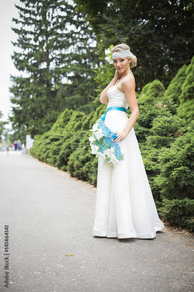 Blonde woman in wedding dress holding bouquet