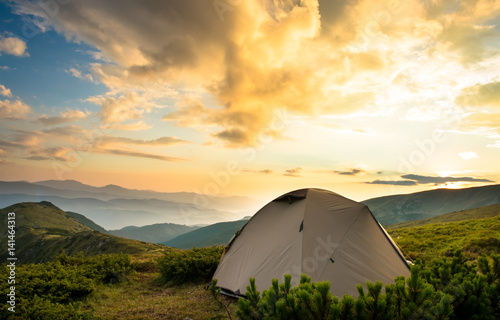 Tourist tent in sunset mountains