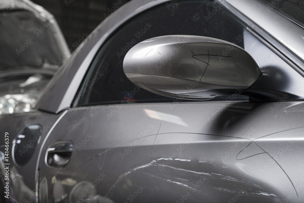 Auto body repair series : Closeup of damaged grey sport car with scratches