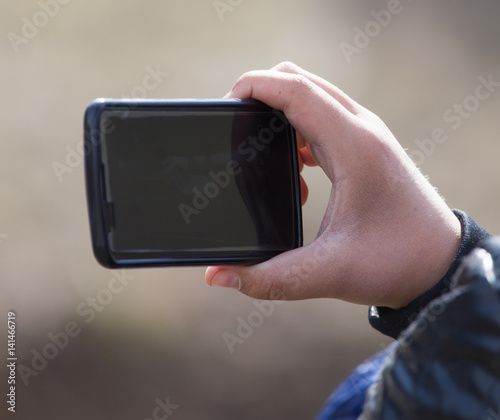 The hand with the phone shoots video