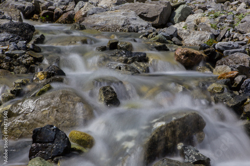 Floating water in a natural mountain stream with stones