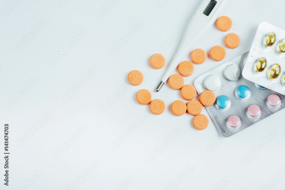 Flu. Thermometer with elevated temperature and many pills on light background Flu. Thermometer with elevated temperature and many pills on light background