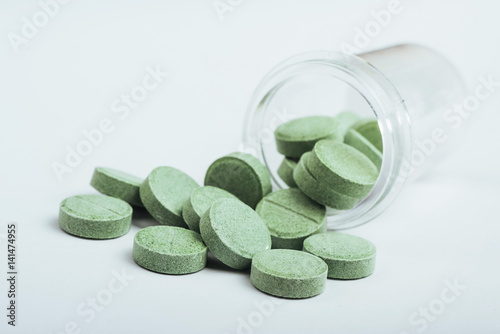 Medical green pills for treatment and health care on a white background photo