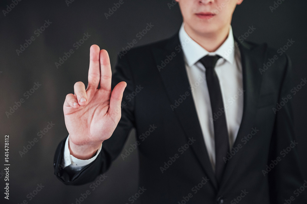 Young businessman in a suit shows his hand Young businessman in a suit shows his hand