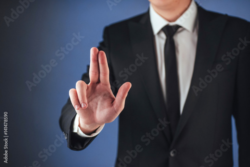 Young businessman in a suit shows his hand