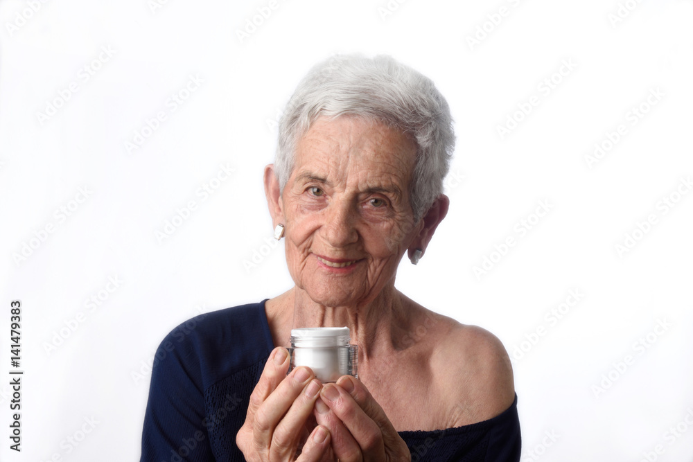 Senior woman applying skin cream or moisturiser to her face Senior woman applying skin cream or moisturiser to her face