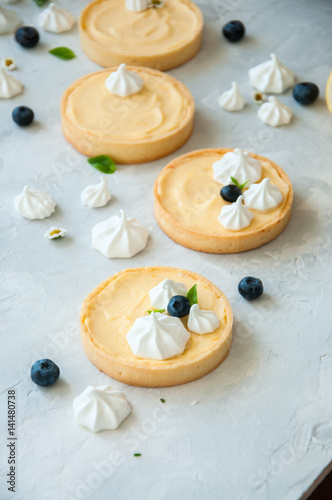 Wallpaper Mural Lemon curd and blueberry jam tarts with meringue and basil leaves Chamomiles whole and slices of fresh lemon on a white stone background. Copy Space. Flat lay. Top View. Torontodigital.ca