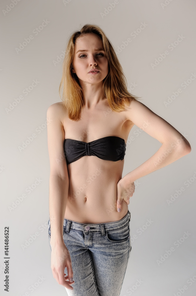 Pretty young blonde in black bra and jeans Stock Photo