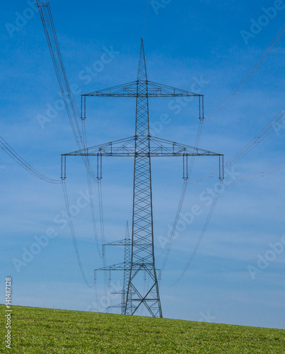 Hochspannungsleitung vor strahlend blauem Himmel, vertikal mit Textfreiraum photo