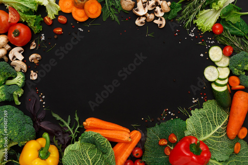 Frame of fresh vegetables on black background with copy space