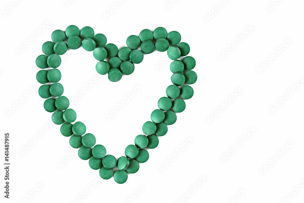 Obraz premium spirulina tablets on white background. Heart