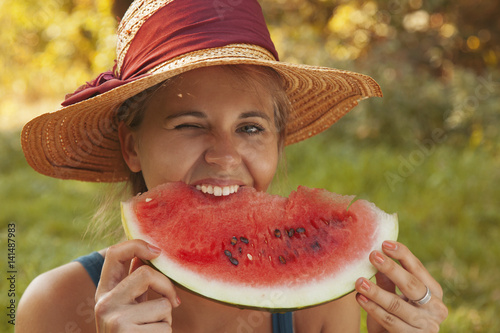 Beautiful happy young woman eating watermelon outdoodrs. Vitamins, nutritional vegetarian food, holiday, diet concept.