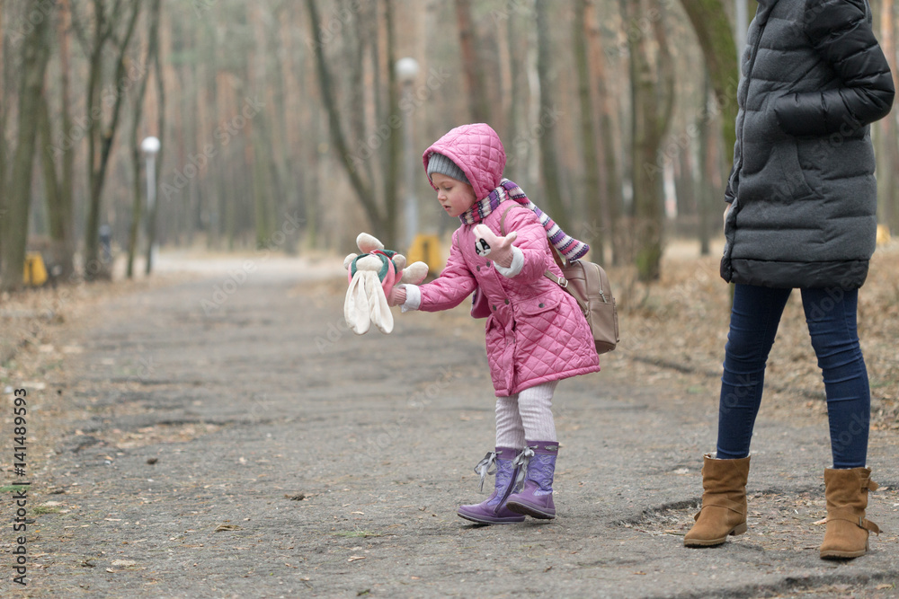 Fototapeta premium Little girl dropped the doll on a walk