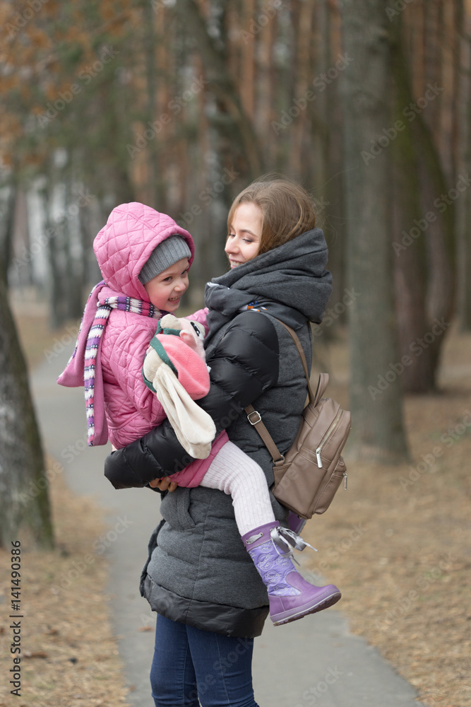 Mom and daughter are walking around the park in the hand