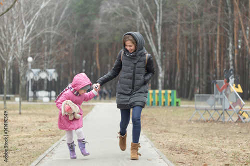 Mom and daughter are walking around the park in the hand