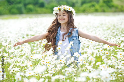 Beautiful little girl on nature with flowers 