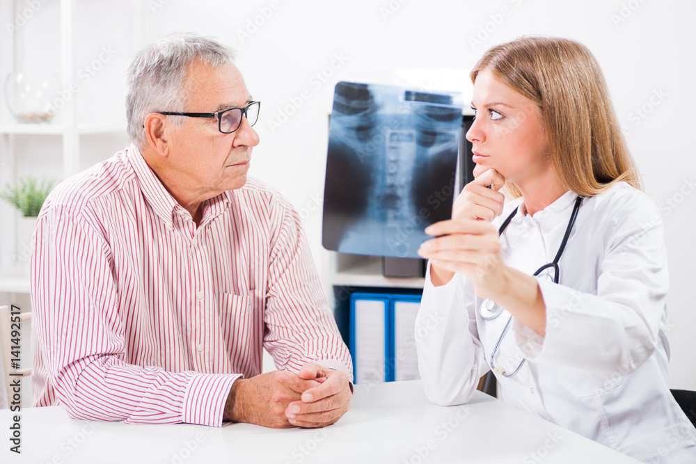 Obraz premium Doctor is showing x-ray snapshot to her patient. 