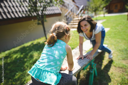 Girl with Mother on Seesaw