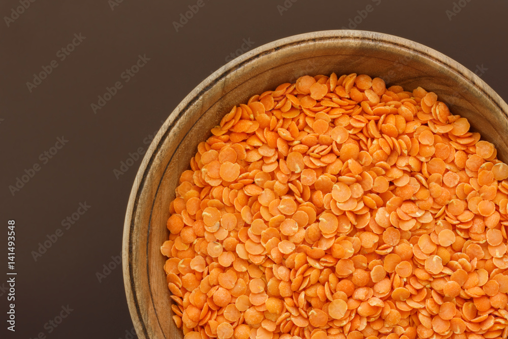 Red lentils in a pottery top view. Background with texture of grains of lentils. Orange bright food background top view. Red lentils in a pottery top view. Background with texture of grains of lentils. Orange bright food background top view.