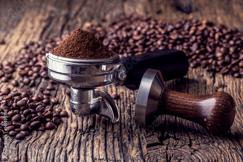 Coffee.Coffee beans and portafilter on old oak wooden table.