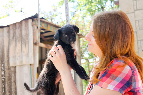 young woman holding a puppy black