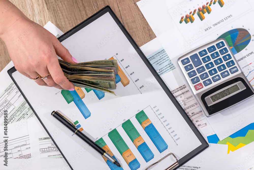 woman counts the money on the background of graph business concept.