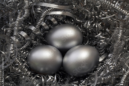Three silver eggs in a nest of metal shavings