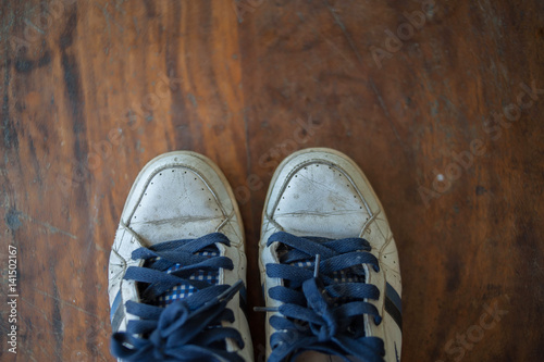 Old worn sneakers on a background of boards