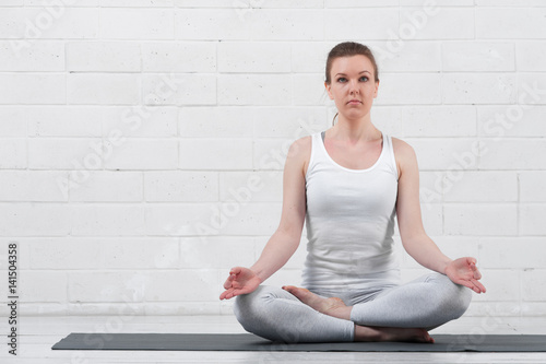 Relaxed woman sitting in yoga meditation pose