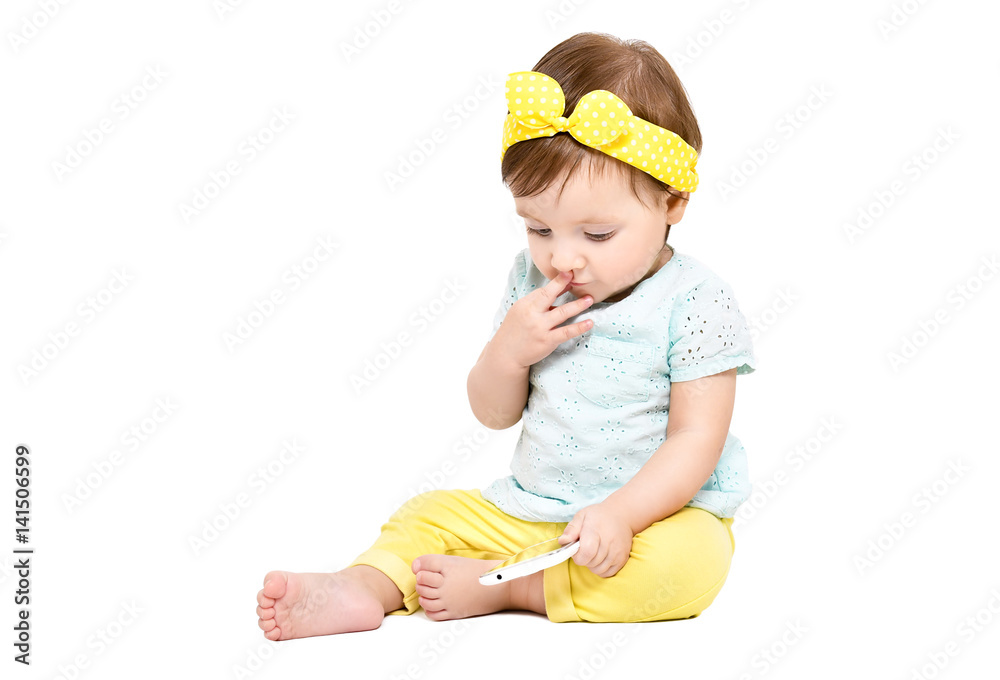 Thoughtful cute little girl, sitting with a mobile phone, isolated on white background Thoughtful cute little girl, sitting with a mobile phone, isolated on white background