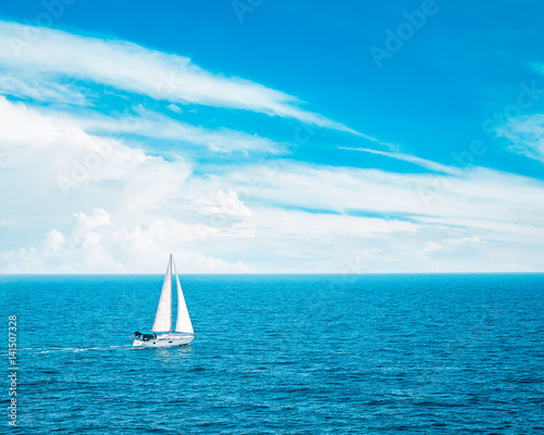 Beautiful Seascape with White Yacht Sailing in Blue Sea. Clouds on the Bakground. Toned Photo with Copyspace.