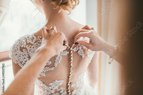 Bridesmaid preparing bride for the wedding day