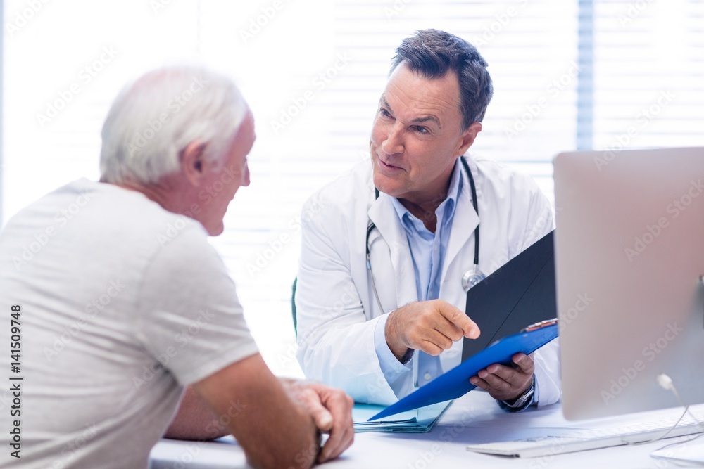 Doctor and senior man discussing on file Doctor and senior man discussing on file