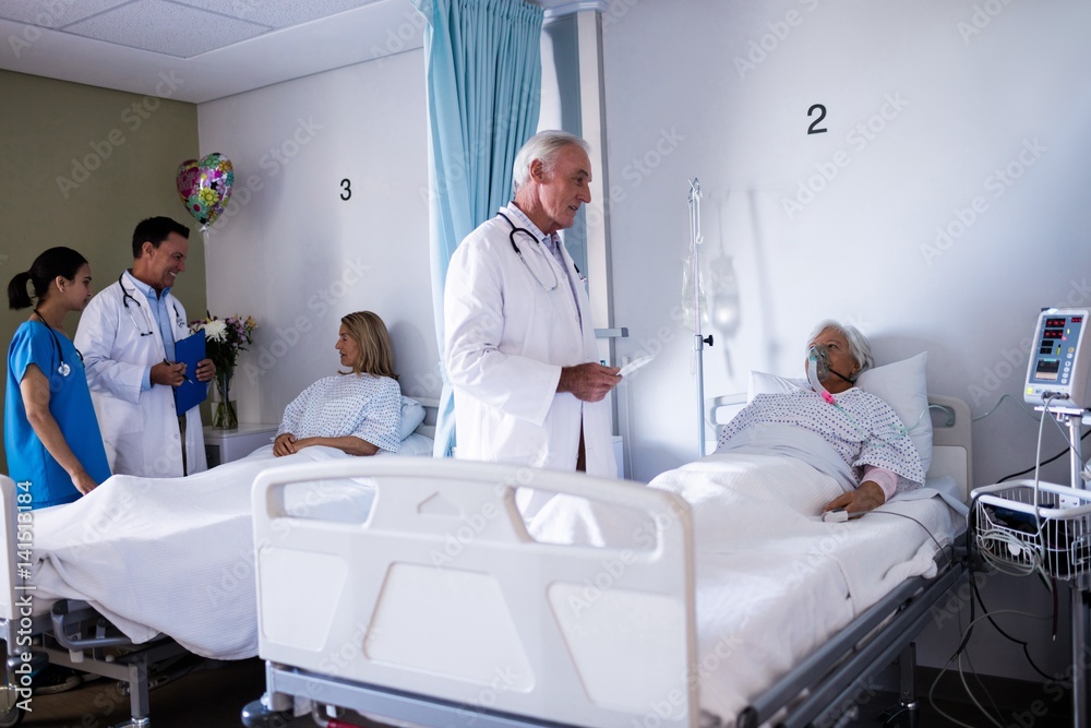 Obraz premium Male doctor interacting with senior patient in the ward