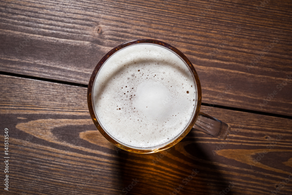 Mug of beer on an old wooden table. Top view Mug of beer on an old wooden table. Top view