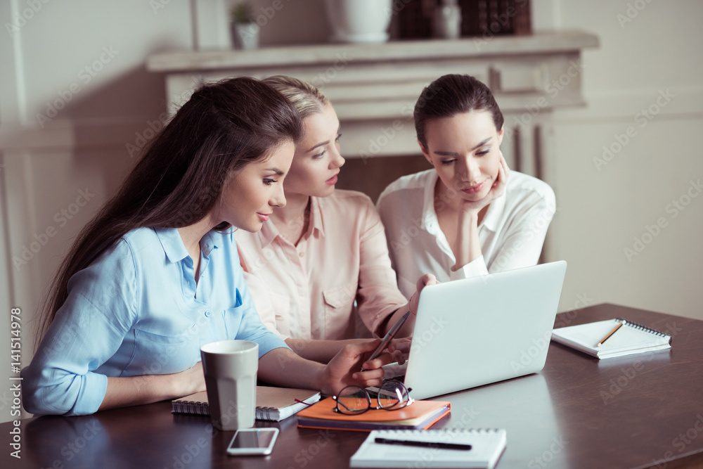 side view of focused businesswomen working on new project together