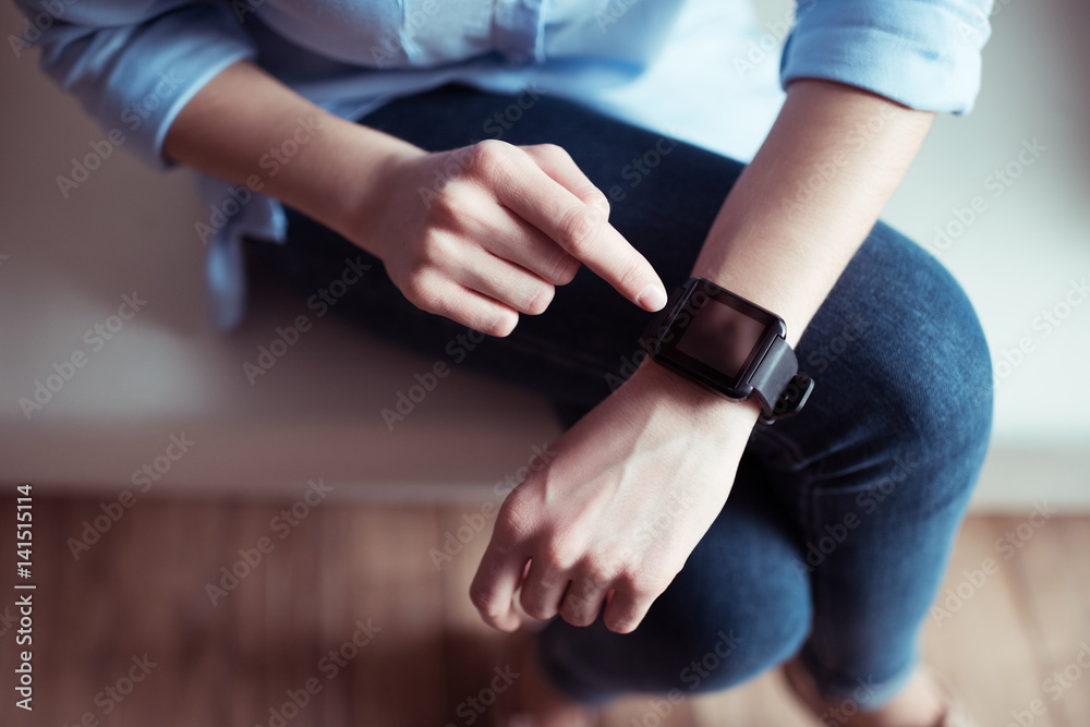 partial view of woman pointing at smartwatch screen