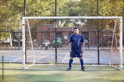 Portrait of a soccer player standing in front of goal