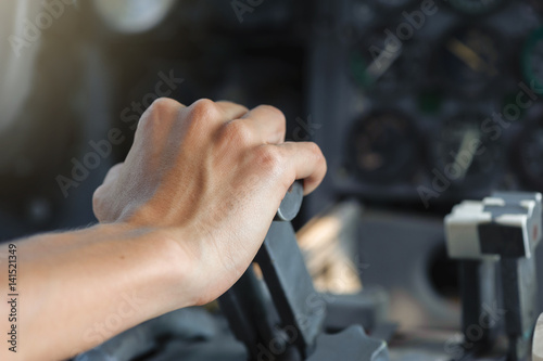 Airplane Cockpit thrust levers with female hand on top for takeoff