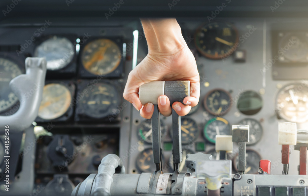 Airplane Cockpit thrust levers with female hand on top for takeoff