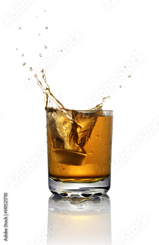 Splash in glass of scotch whiskey with ice