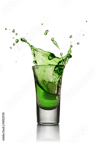 Glass of alcoholic drink with ice. Absinthe or mint liquor shot photo