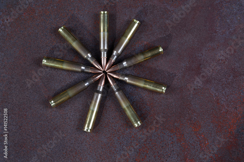 Group of ammunition geometrically placed. Ammo circle on a rusted metal background