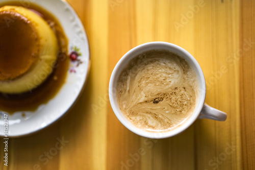 One white cups with aroma refreshing coffee on a kitchen table, cream witfh heart on the top. Top wieu, blured caramel cream on the left. photo