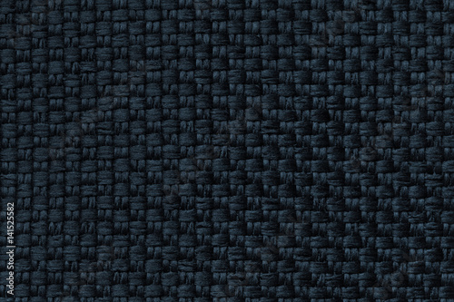 Dark blue background with checkered pattern, closeup. Structure of the fabric macro.